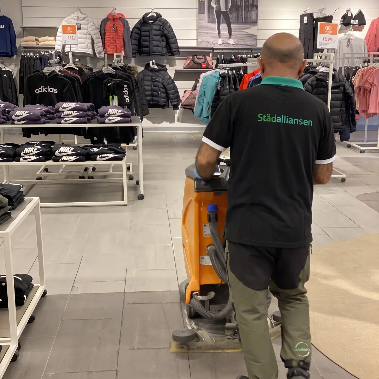 Medarbetare kör golvvårdsmaskin i butik