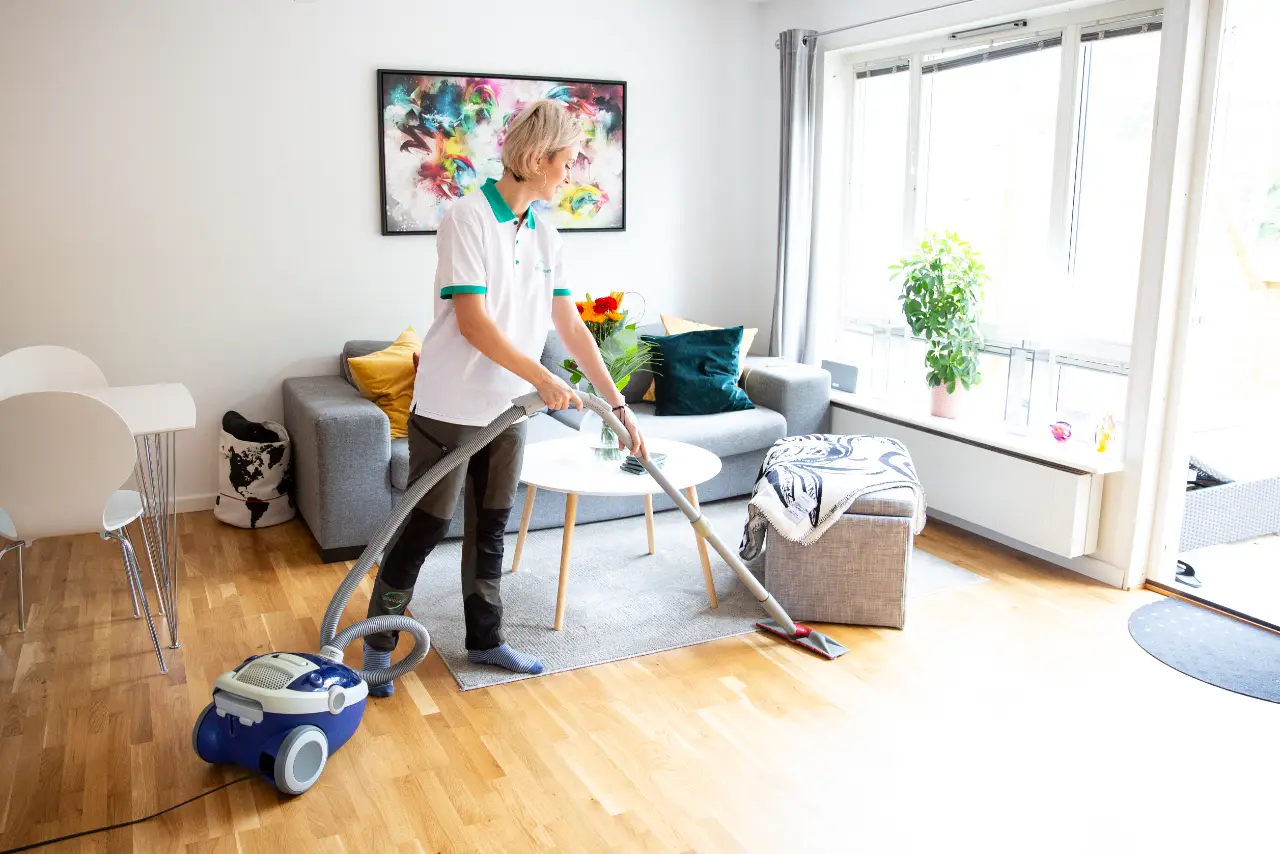 Medarbetare från Städalliansen dammsuger ett hem