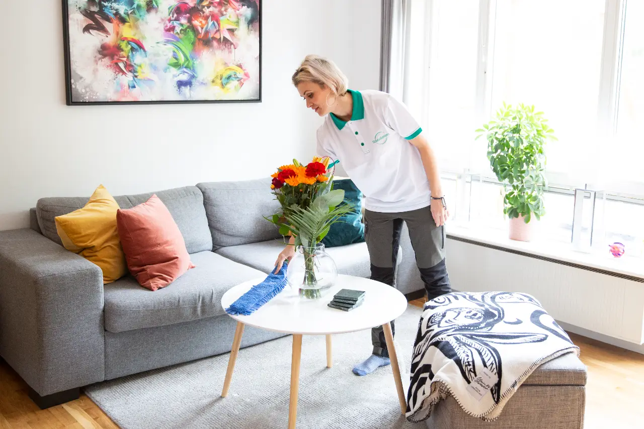 Medarbetare från Städalliansen städar ett ljust vardagsrum