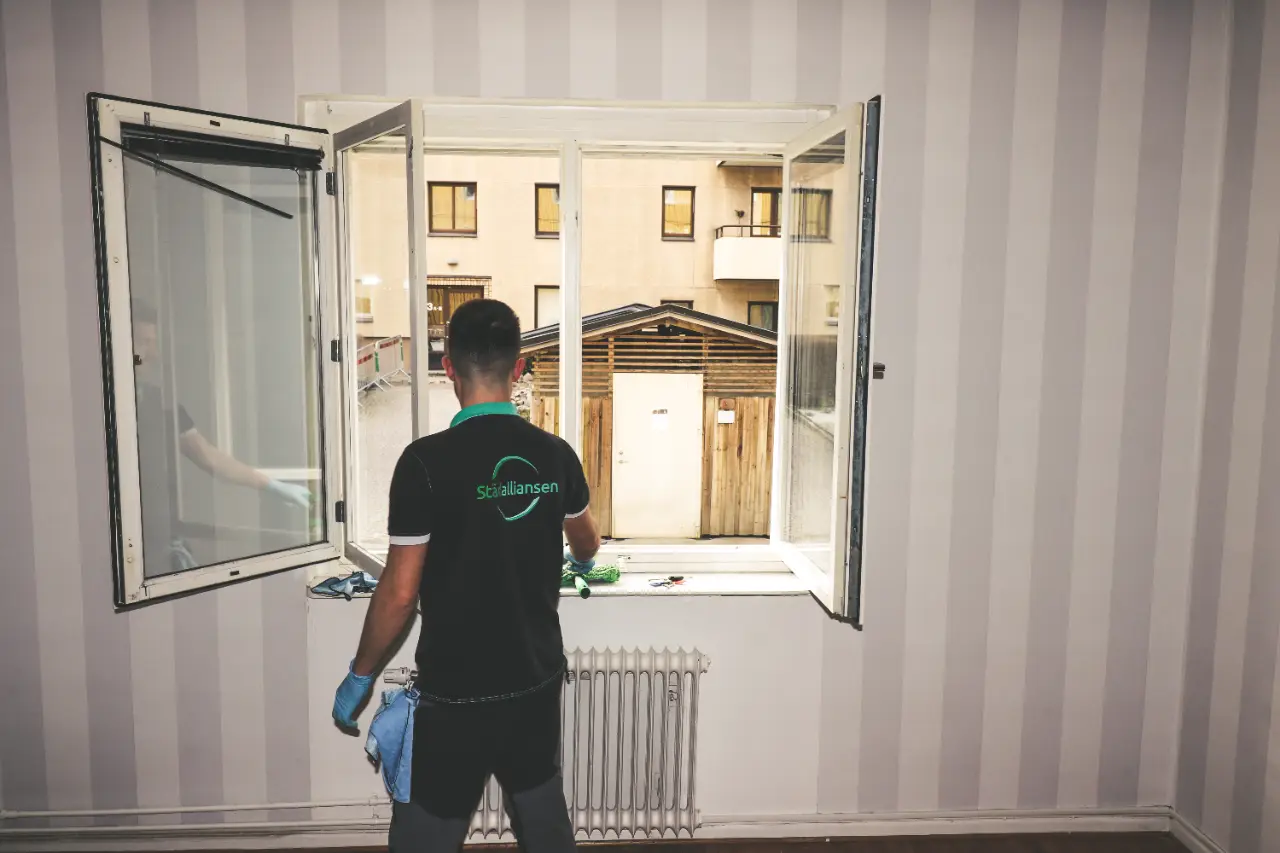 Städare från Städalliansen putsar ett öppet bostadsfönster invändigt
