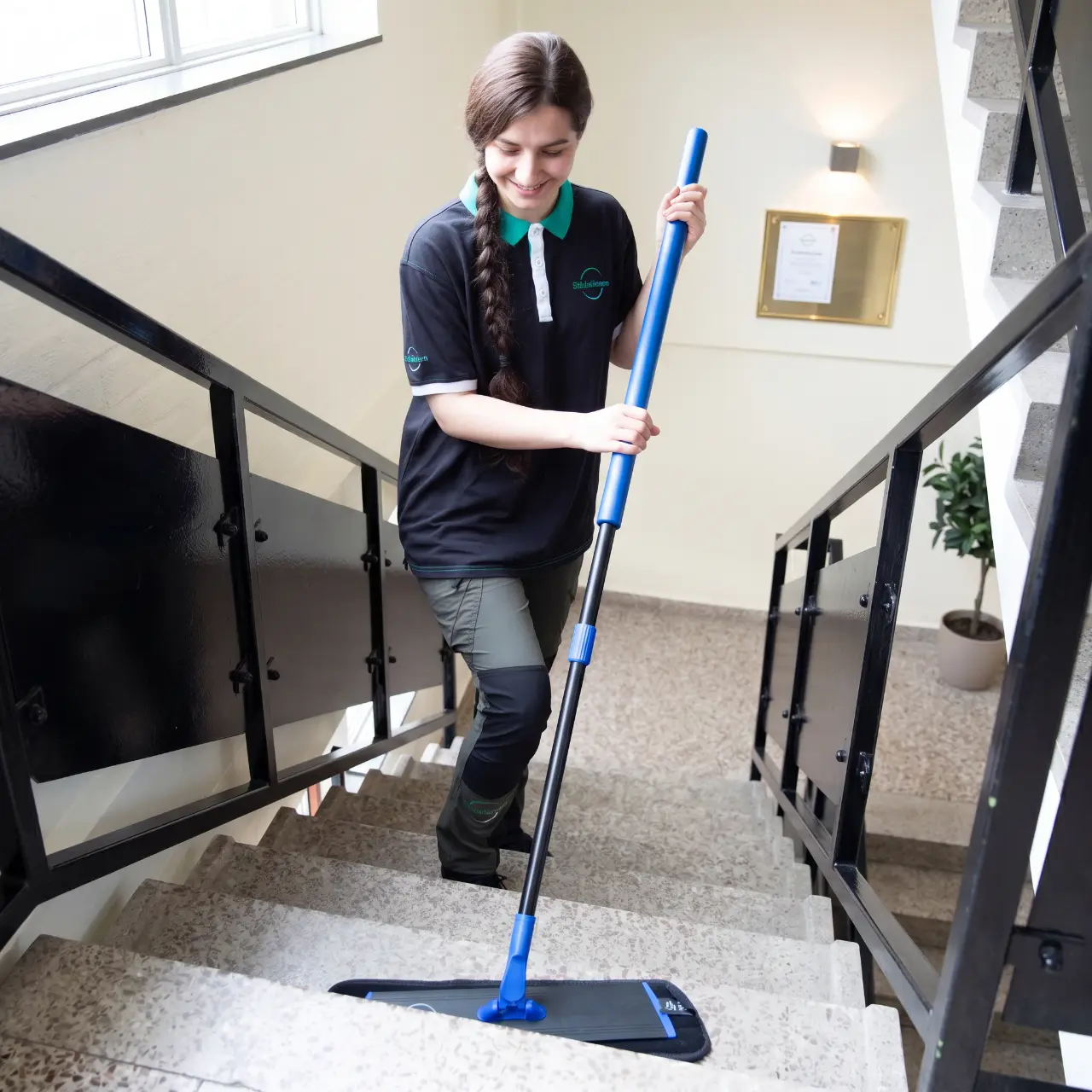 Städare från Städalliansen moppar trappsteg i ett modernt trapphus